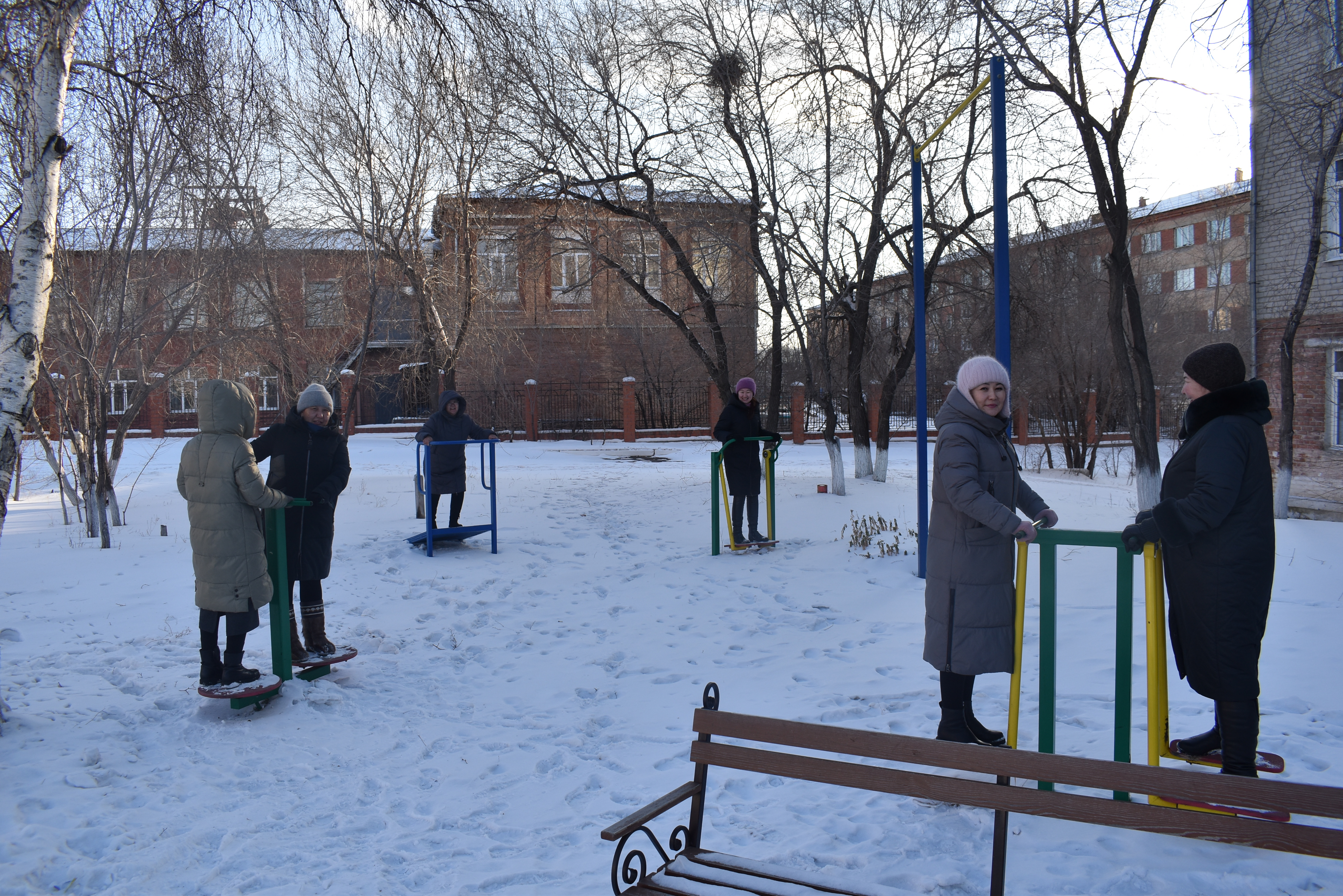 Занятие на спортивных тренажерах на свежем воздухе.